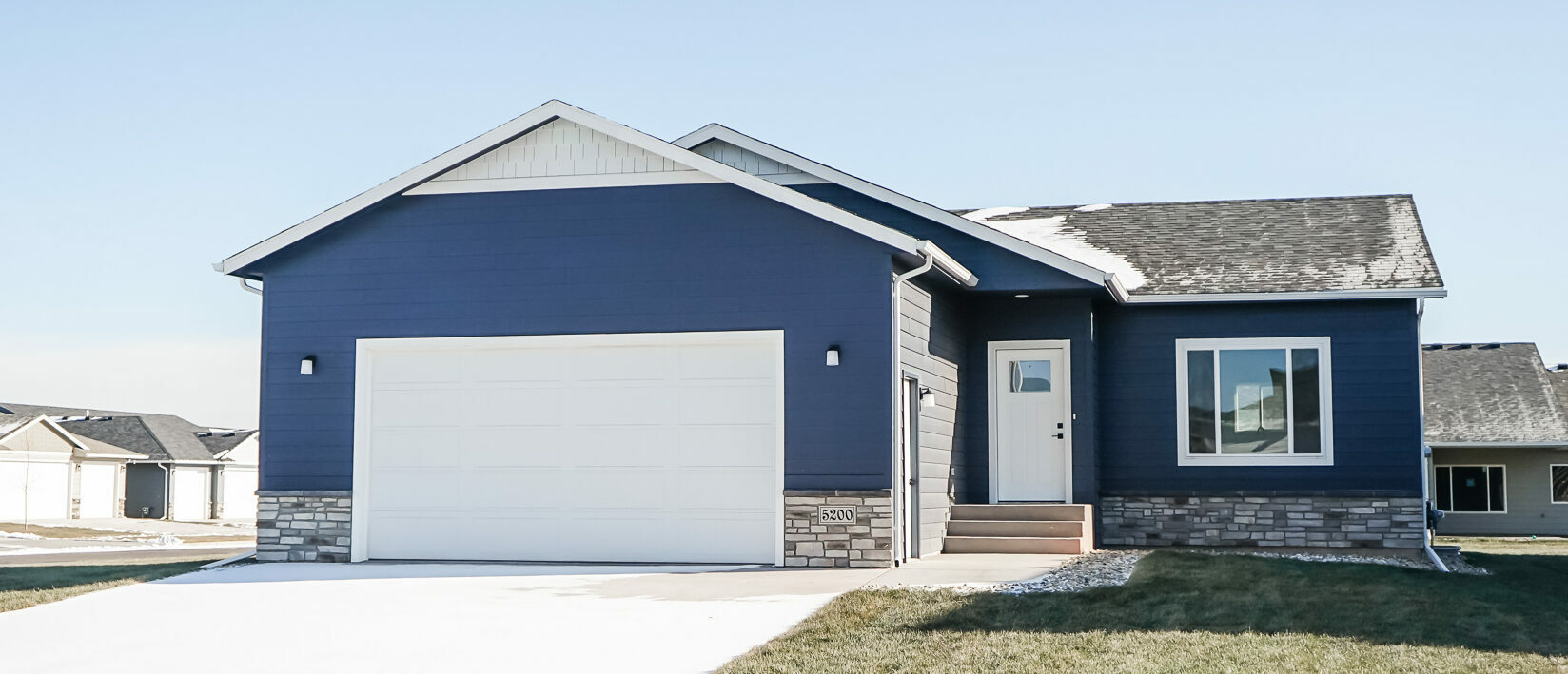 Single Family Home with Stone Detail, a white front door and two stall garage door