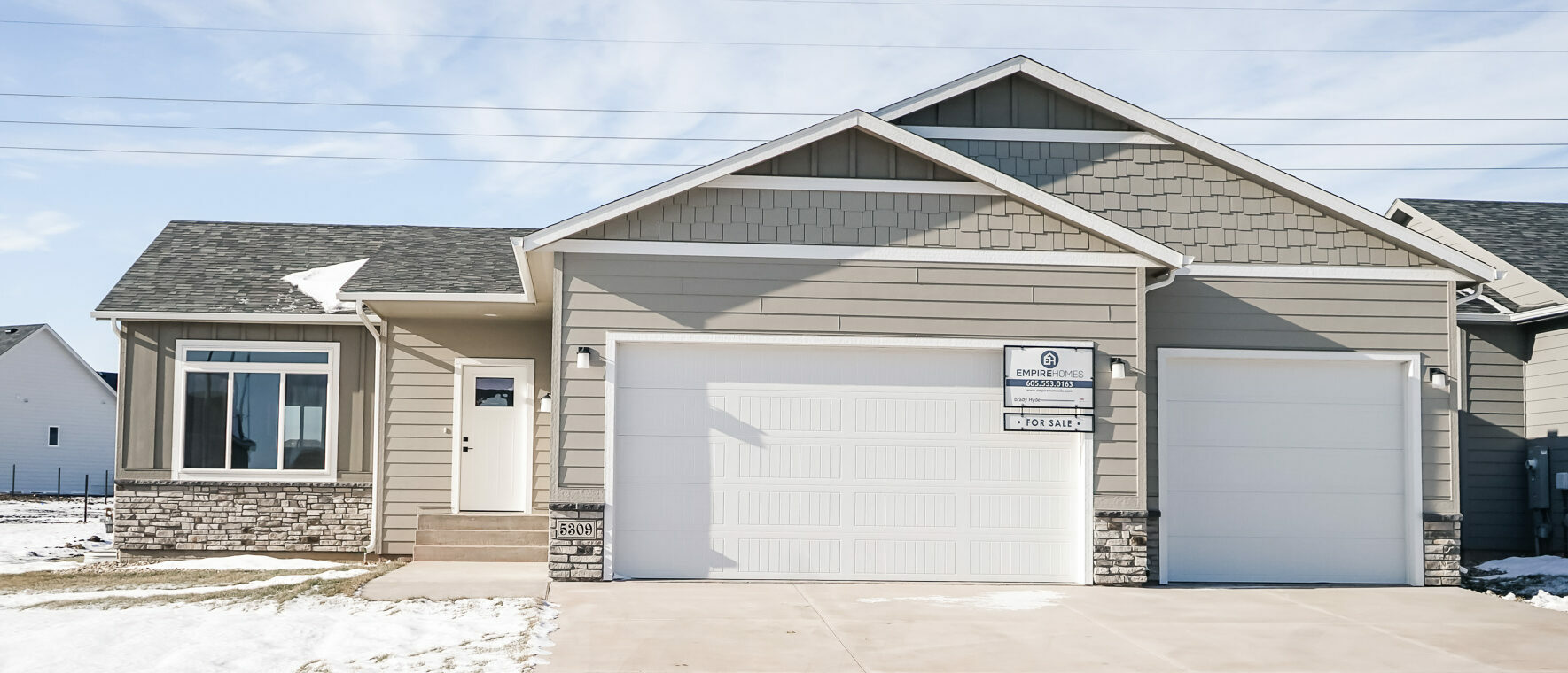 Single Family Home with large front window next to a White Front door and three stall garage