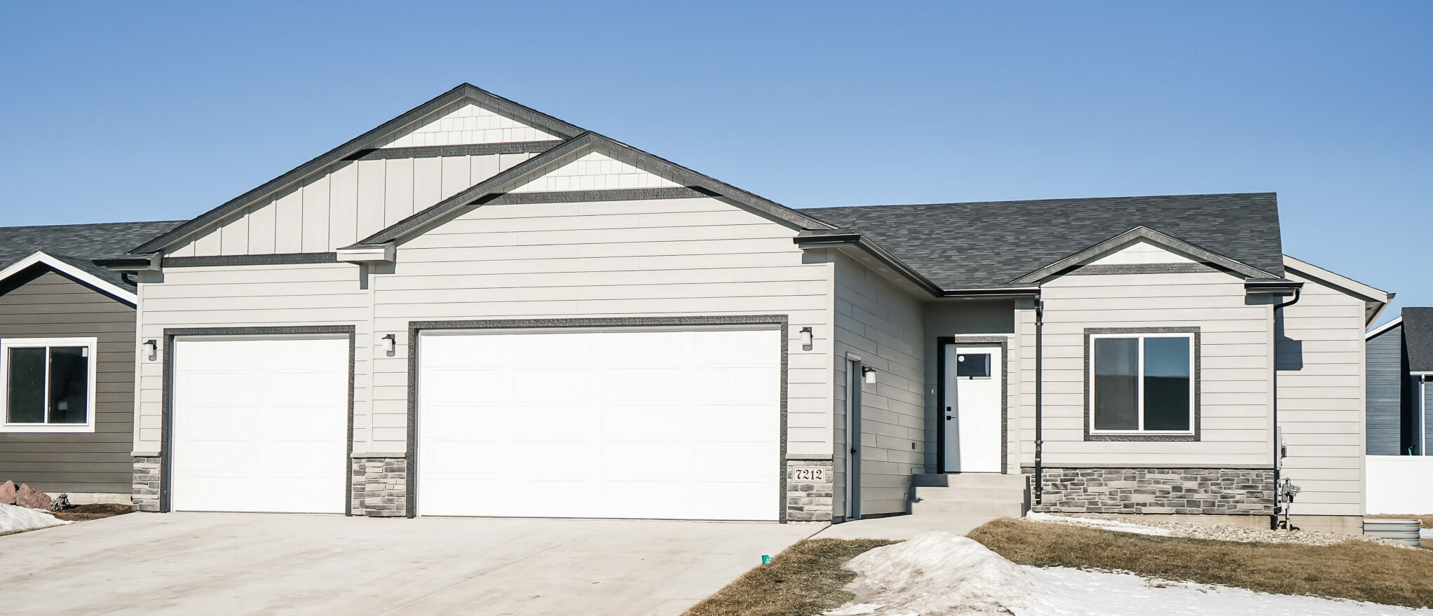 Single Family Home with White Front Door and Three Stall Garage with stone details