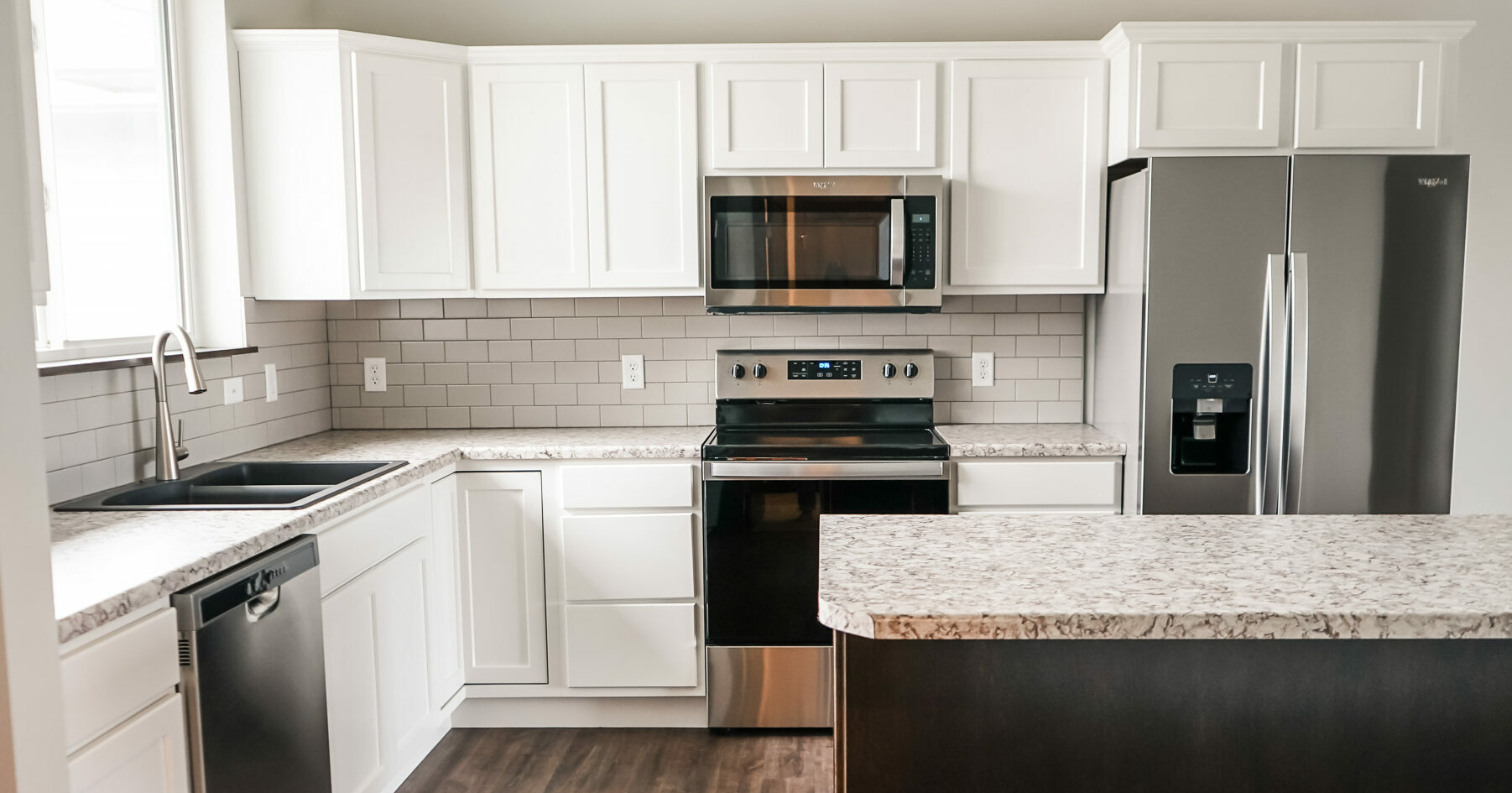 White custom cabinet kitchen with dark stain island and light laminate countertops