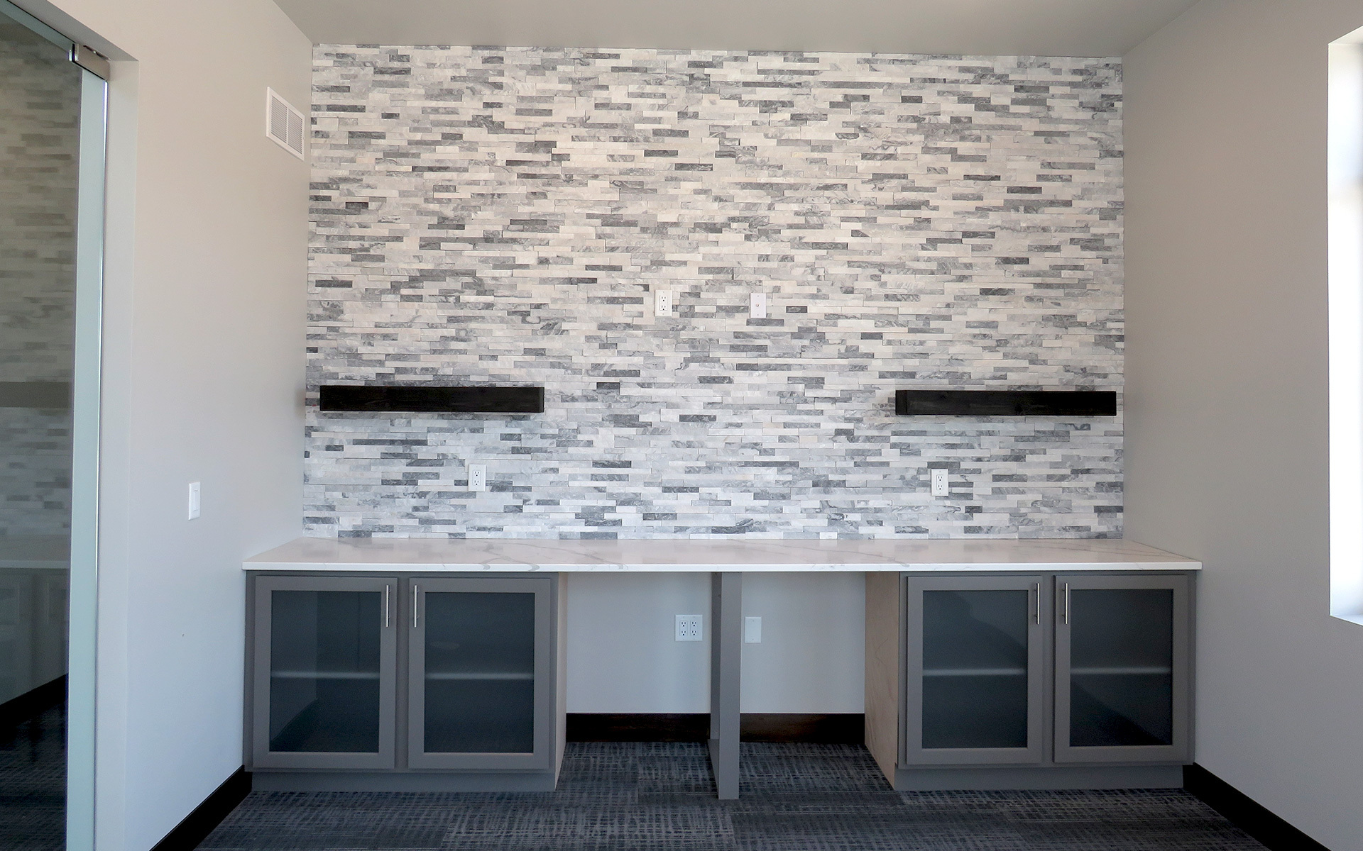 A tile backsplash behind floating shelves shows off the modern details of a home.