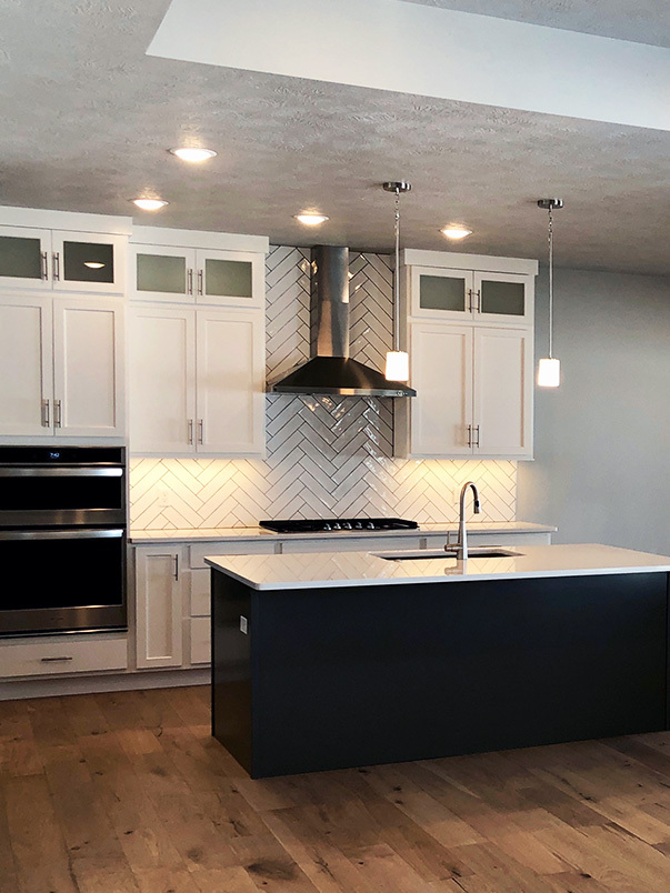An open concept kitchen features white, modern cabinets