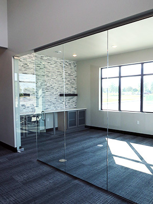 A modern office space features glass walls and a neutral color scheme.