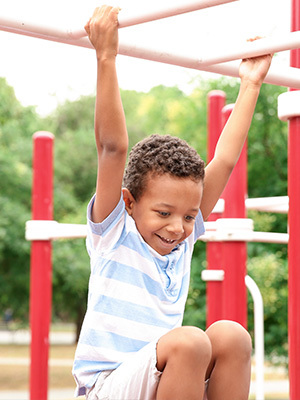 A child plays on the monkey bars at a playground.